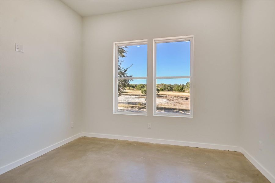 Unfurnished room with baseboards and concrete floors