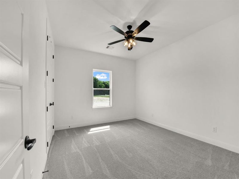 Unfurnished room with light carpet, baseboards, and ceiling fan