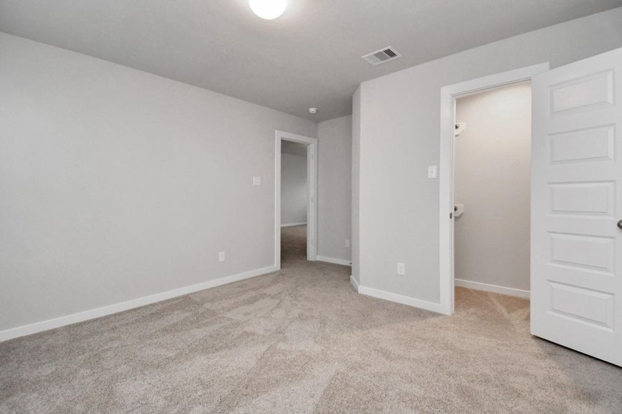 Secondary bedroom features plush carpeting, large windows that let in plenty of natural light, bright paint, and spacious closets. Sample photo of completed home with similar floor plan. Actual colors and selections may vary. Secondary bedroom features plush carpeting, large windows that let in plenty of natural light, bright paint, and spacious closets. Sample photo of completed home with similar floor plan. Actual colors and selections may vary.
