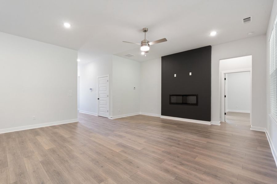 Wood-finish flooring, recessed lighting, and a linear electric fireplace