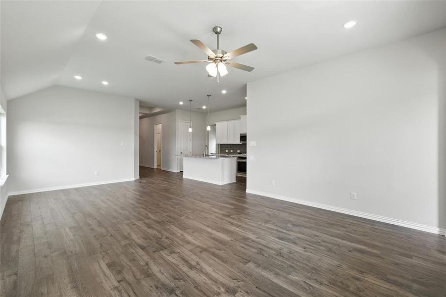 Unfurnished living room with ceiling fan, dark wood-type flooring, recessed lighting, and lofted ceiling