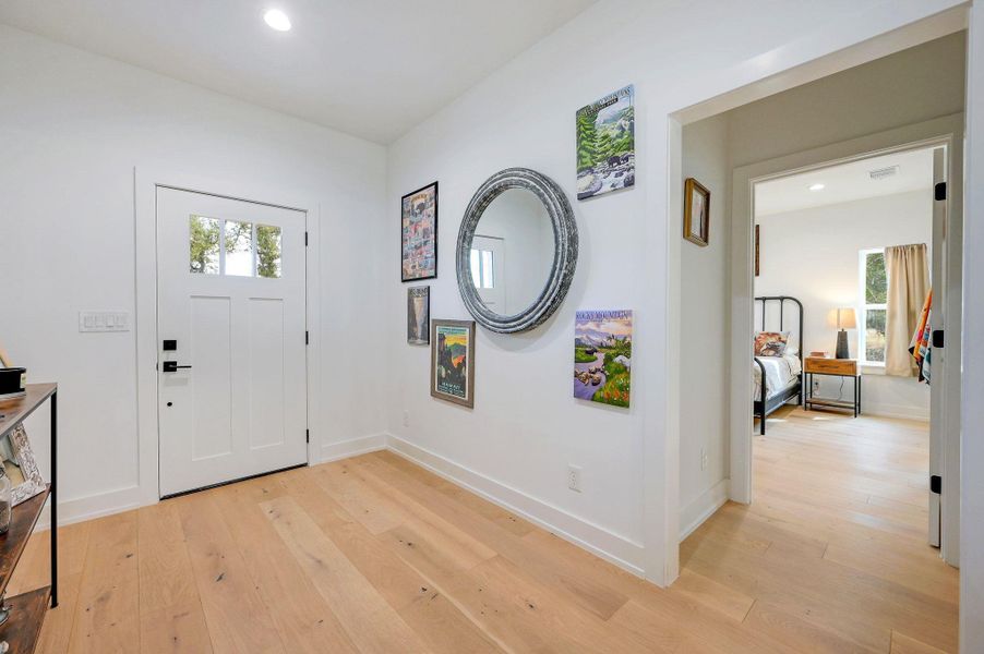Foyer entrance featuring light wood finished floors and recessed lighting