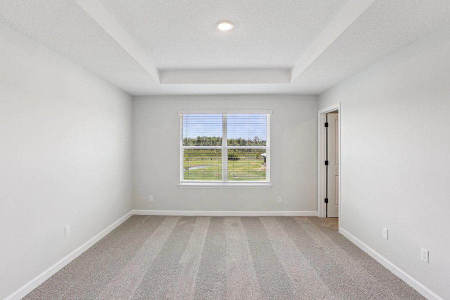 Spacious primary bedroom with a tray ceiling -  Representative images and renderings are for illustrative purposes