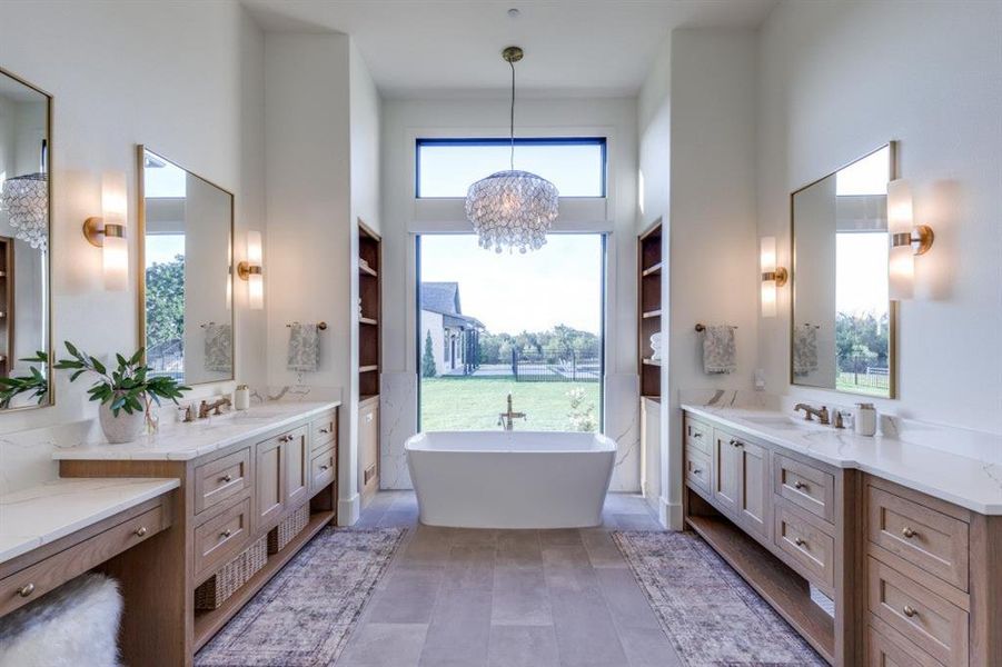 Full bathroom with two vanities, a freestanding tub, a chandelier, and a towering ceiling Full bathroom with two vanities, a freestanding tub, a chandelier, and a towering ceiling