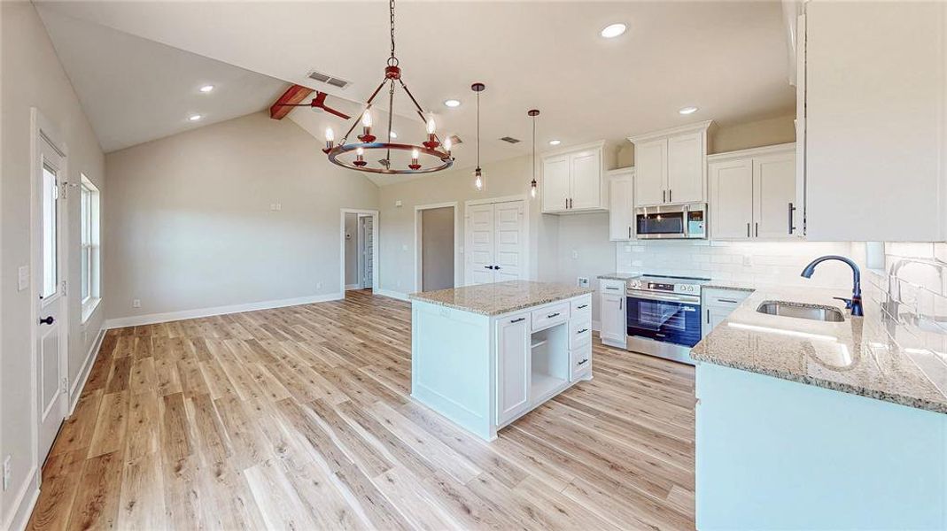 Kitchen with a chandelier, stainless steel appliances, light wood-style floors, decorative backsplash, and white cabinetry Kitchen with a chandelier, stainless steel appliances, light wood-style floors, decorative backsplash, and white cabinetry