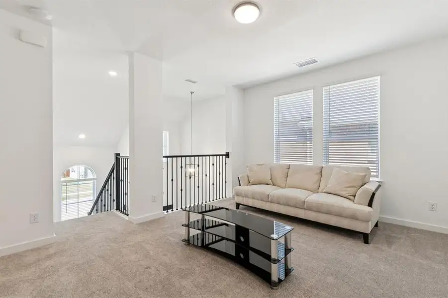Living area featuring light colored carpet, recessed lighting, and a high ceiling Living area featuring light colored carpet, recessed lighting, and a high ceiling