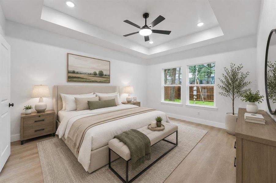 Spacious bedroom featuring a tray ceiling with recessed lighting and a ceiling fan Spacious bedroom featuring a tray ceiling with recessed lighting and a ceiling fan