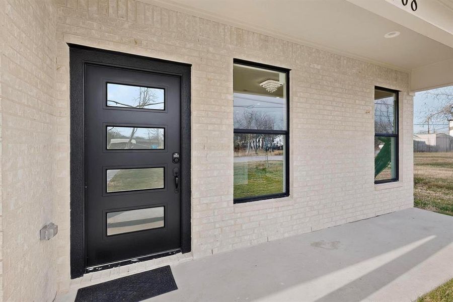 Entrance to property featuring brick siding and a patio area Entrance to property featuring brick siding and a patio area