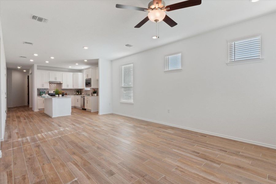 Open floor plan- living room featuring recessed lighting, ceiling fan, and light wood-tile  floors
