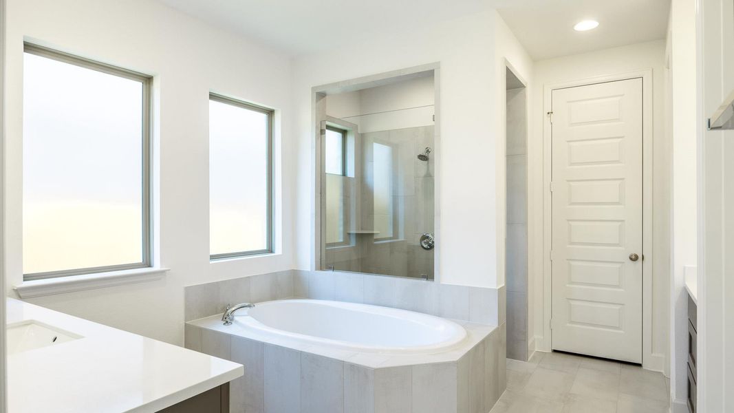 Bathroom with vanity, a bath, a tile shower, and light tile patterned floors
