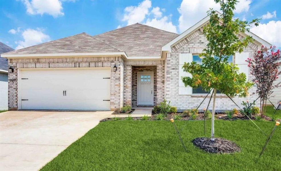 View of front of home featuring a front yard and a garage