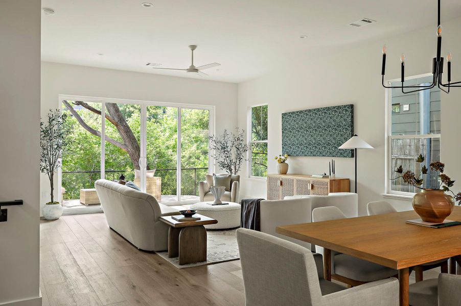 Living area with a ceiling fan, wood finished floors, and a chandelier