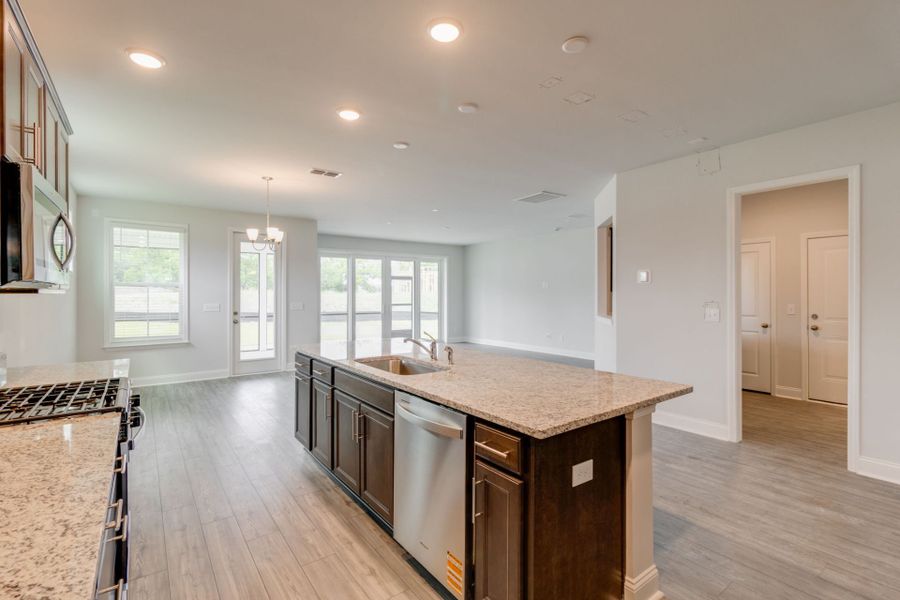 Spacious kitchen including an Island and with stainless steel appliances.