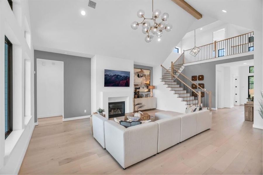 Another view of the family room. Note the wood beam, modern chandelier and the soft grey accent paint.