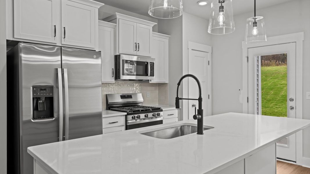 Notable kitchen space with elegant pendant lighting and a large island perfect for entertaining Notable kitchen space with elegant pendant lighting and a large island perfect for entertaining