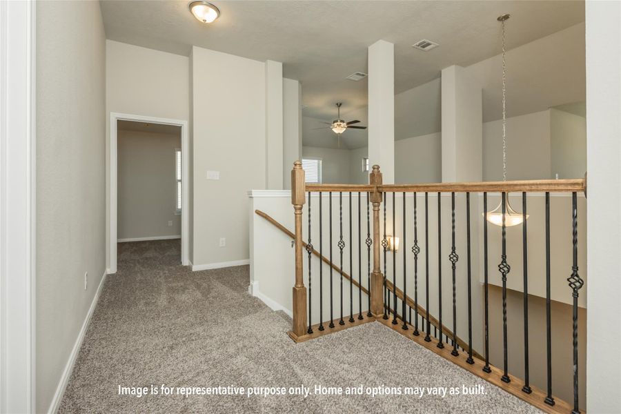 Hall with an upstairs landing and light colored carpet