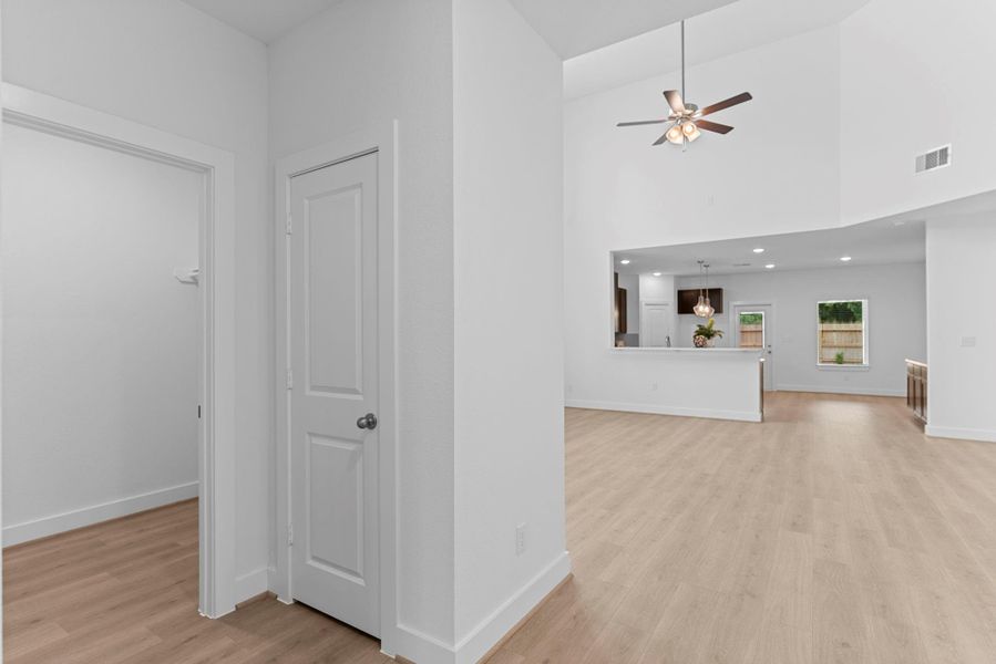 This view highlights the functional layout of the home, with the utility room conveniently located on the left and a glimpse into the spacious family room on the right, perfect for everyday living and flow. **Image Representative of Plan Only and May Vary as Built**.