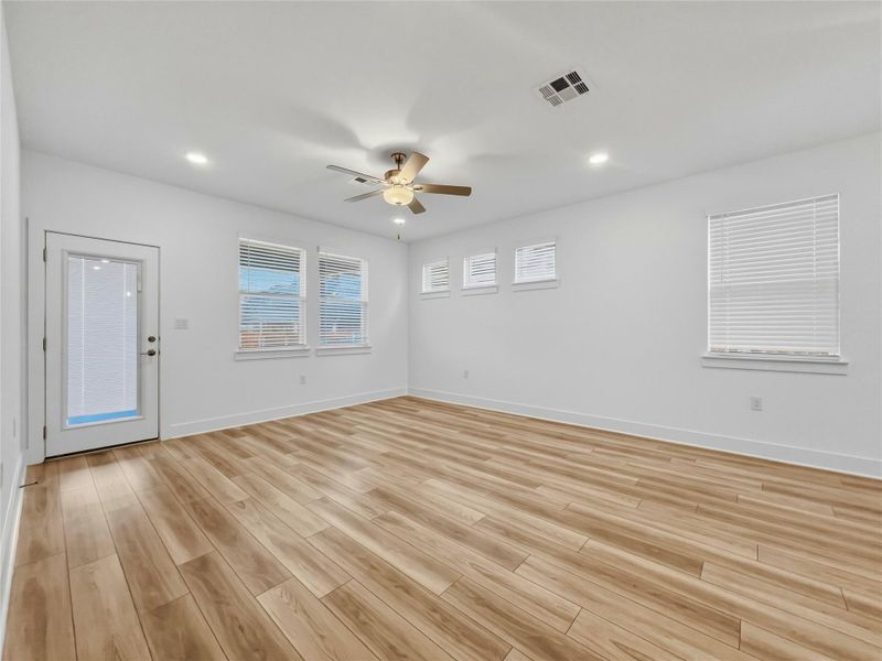 Living room with light wood-style floors, ceiling fan, and recessed lighting