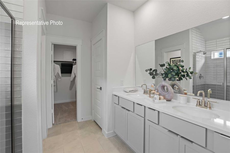 Bathroom featuring vanity, tile patterned floors, and a shower with door