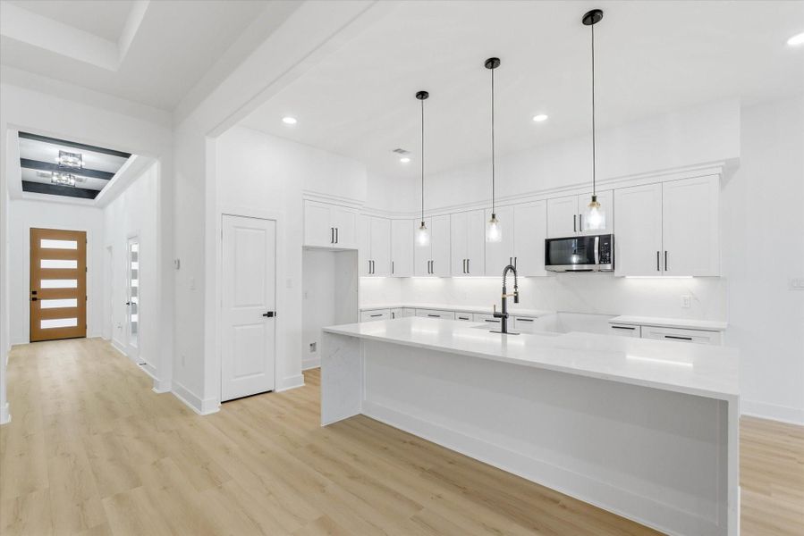 The expansive kitchen island spans nearly 10 feet, offering generous seating and a beautiful waterfall edge.