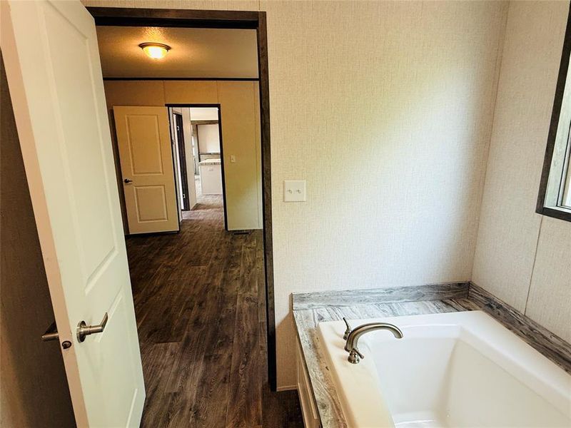 Bathroom featuring a garden tub and wood finished floors
