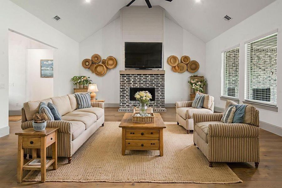 The photo os the family room is digitally staged.  Notice the wide plank wood flooring, the shiplap wall above the fireplace