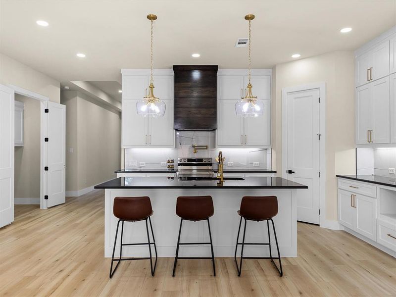 Contemporary kitchen featuring an expansive island with a dark countertop and seating