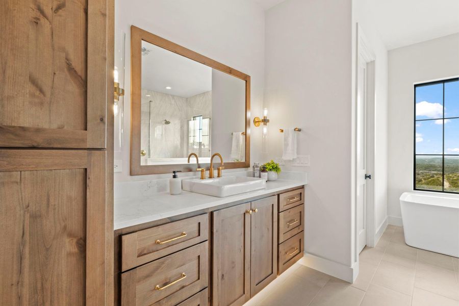 Breathtaking primary bath featuring custom dual vanities, a soaking tub, walk in shower, and under cabinet lighting.