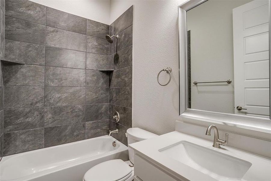 Full bathroom featuring vanity, toilet, and tiled shower / bath