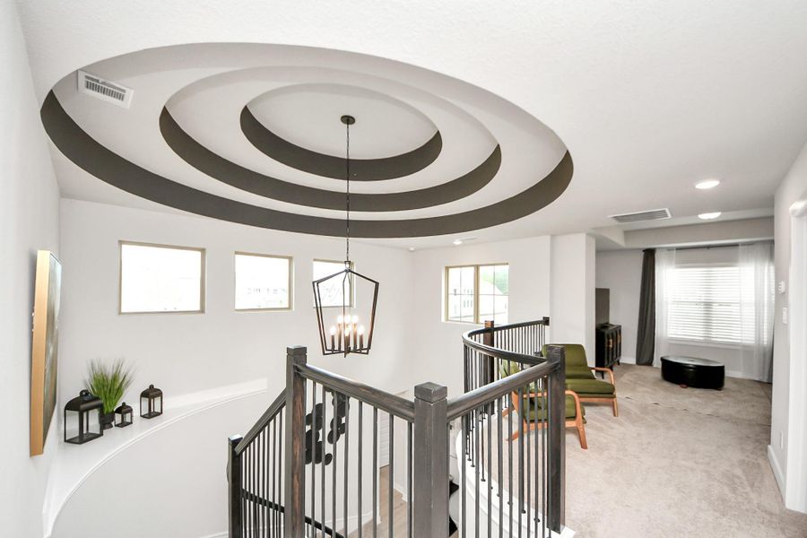 Flexible upstairs space with overlook and striking concentric ceiling.
