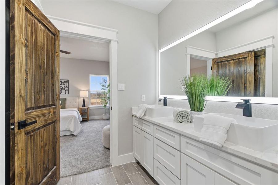 Full bath with connected bathroom, double vanity, and wood finish floors