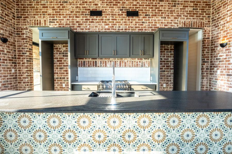 Kitchen with brick wall and stainless steel gas cooktop