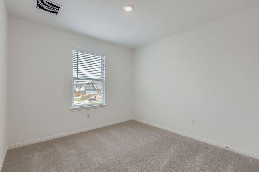 Empty room with carpet flooring and baseboards Empty room with carpet flooring and baseboards