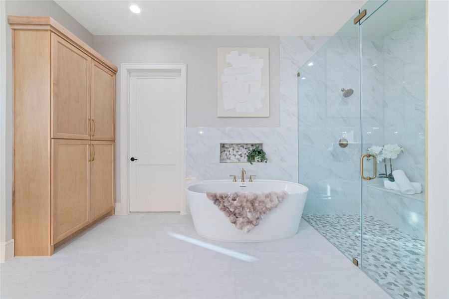 Spa-inspired primary bath featuring soaking tub and glass walk-in shower.
