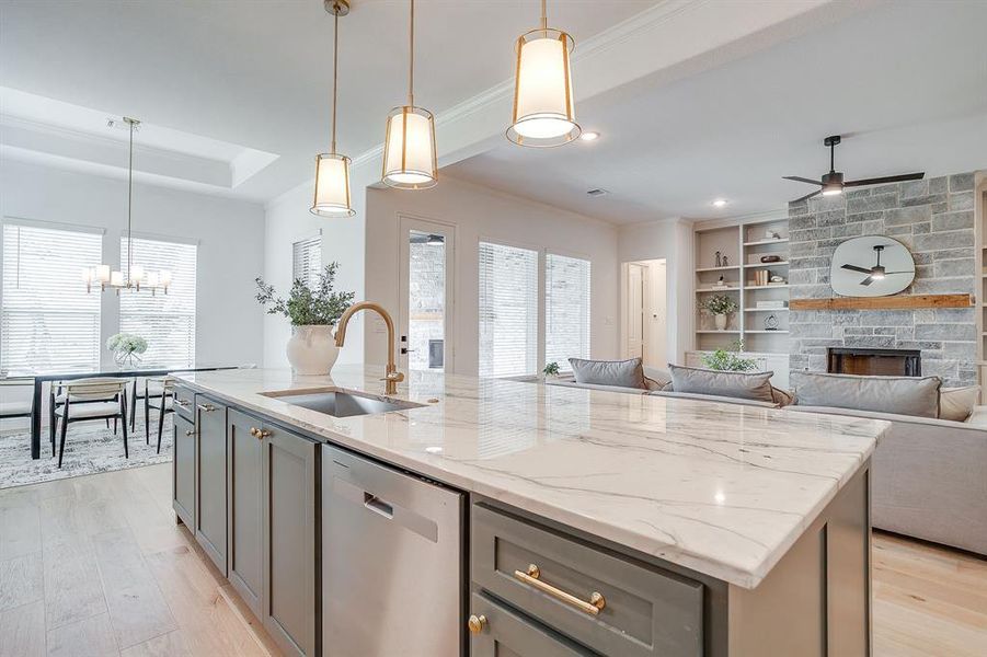 Kitchen with custom cabinets to the ceiling, leathered Quartzite counters, tile backsplash, decorative lighting, ample storage, soft close doors and drawers, and gas cooktop. Kitchen with custom cabinets to the ceiling, leathered Quartzite counters, tile backsplash, decorative lighting, ample storage, soft close doors and drawers, and gas cooktop.