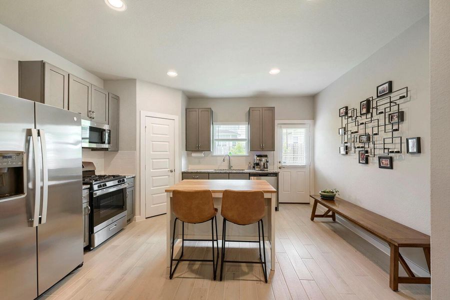 A well-lit kitchen with sleek stainless steel appliances and a functional central island. A well-lit kitchen with sleek stainless steel appliances and a functional central island.