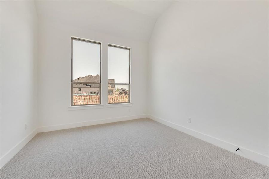 Empty room with light carpet and vaulted ceiling Empty room with light carpet and vaulted ceiling