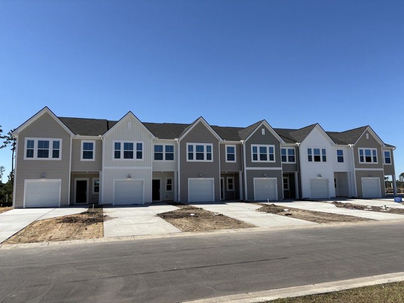 Front exterior of a new home in Lindera Preserve at Cane Bay Plantation: Townhomes, Summerville, SC, highlighting curb appeal (Image 1). Front exterior of a new home in Lindera Preserve at Cane Bay Plantation: Townhomes, Summerville, SC, highlighting curb appeal (Image 1).