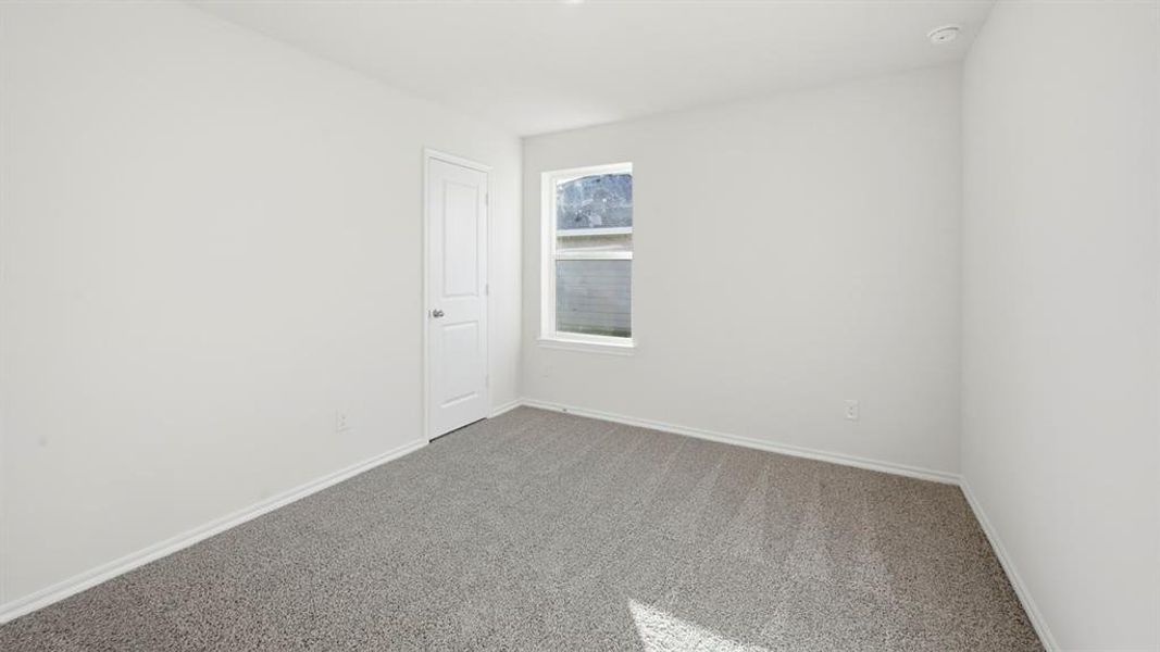 Carpeted spare room featuring baseboards Carpeted spare room featuring baseboards