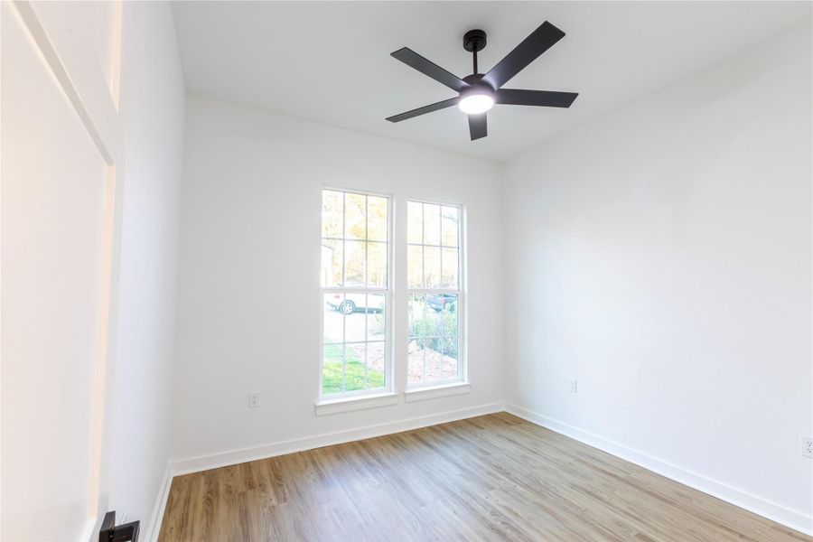 Third bedroom overlooking the front yard, featuring large windows that fill the space with natural light.