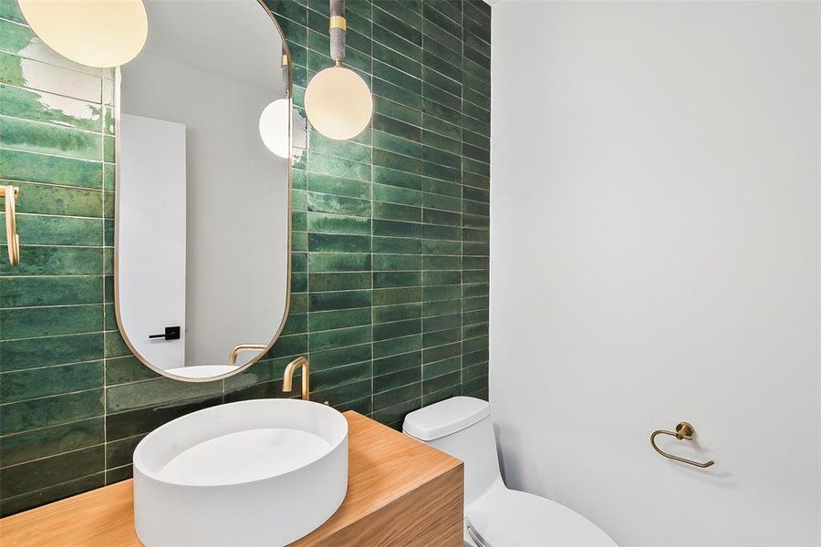 Bathroom featuring hardwood floors, vanity, toilet, and tile walls