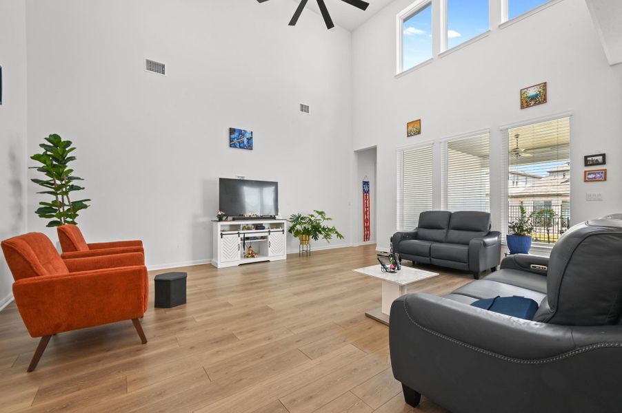 Hardwood floors and soaring double-height walls frame this airy, light-filled gathering space.