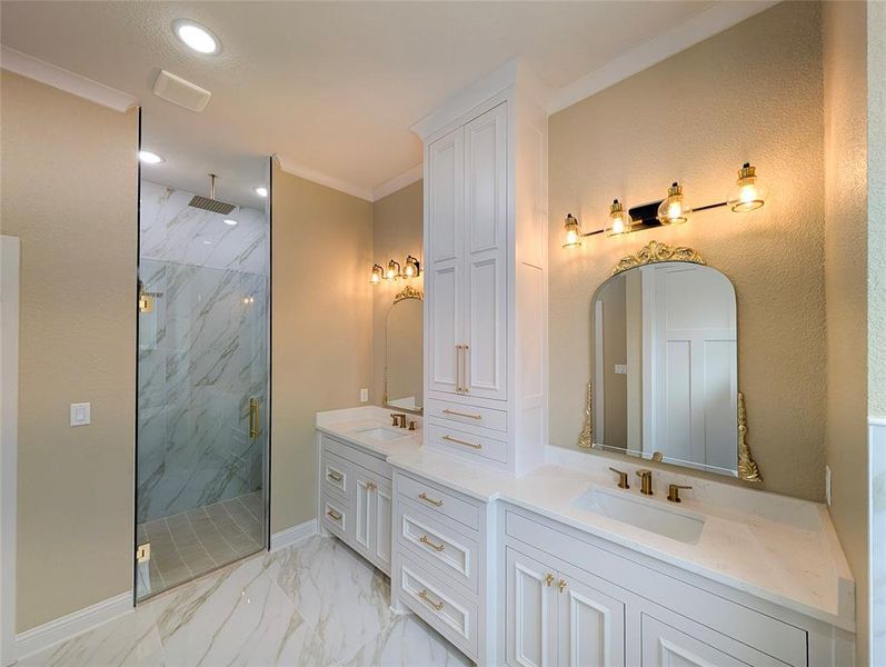 Full bath featuring light marble finish floors, double vanity, a marble finish shower, recessed lighting, and ornamental molding