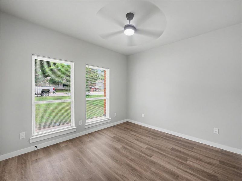 Interior space featuring wood-finish flooring, light gray wall paint, and white trim Interior space featuring wood-finish flooring, light gray wall paint, and white trim