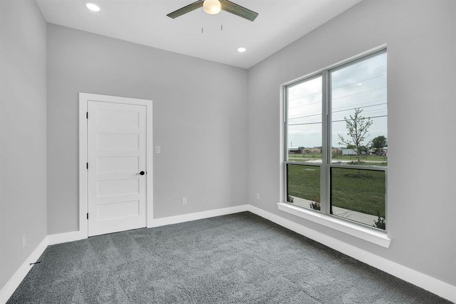 Empty room featuring ceiling fan and carpet floors