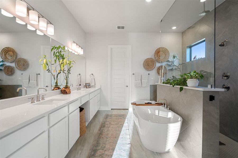 A well-appointed primary bathroom showcases dual vanities, a luxurious soaking tub, and a spacious glass-enclosed shower. A well-appointed primary bathroom showcases dual vanities, a luxurious soaking tub, and a spacious glass-enclosed shower.