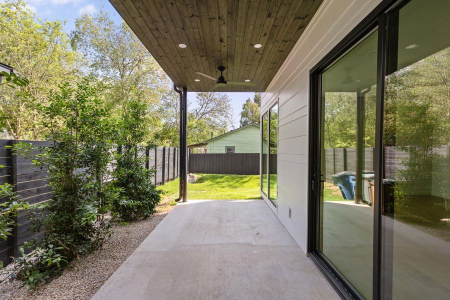 Fenced backyard featuring a ceiling fan and a patio area