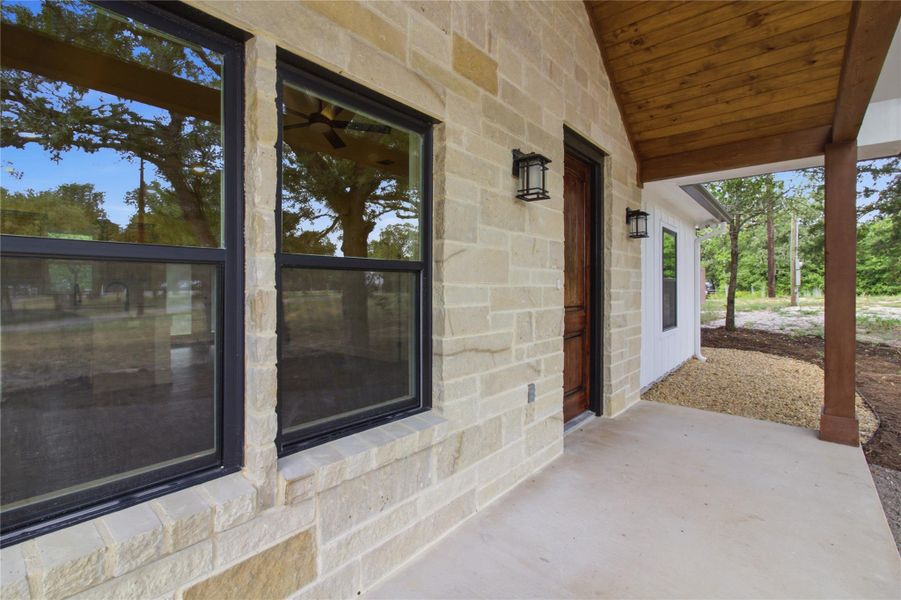 Crafted with durable stone and wood siding, this home features a welcoming covered front porch. Crafted with durable stone and wood siding, this home features a welcoming covered front porch.