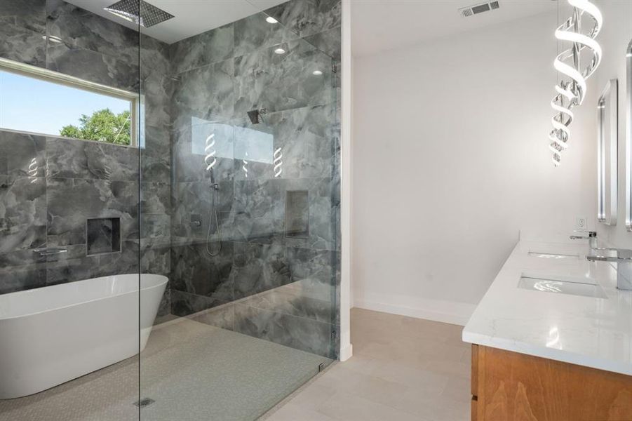 1st floor primary bathroom with large shower - tub combo and dual sinks.