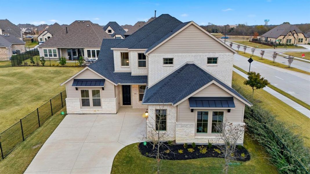 View of front of house with stone siding, a shingled roof, a residential view, concrete driveway, and a standing seam roof